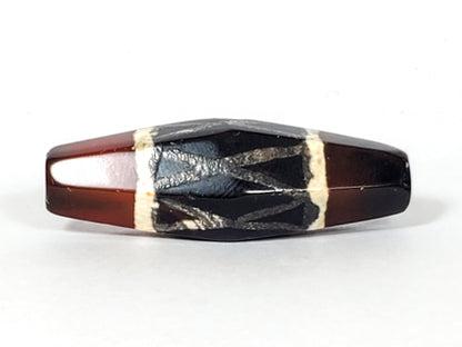 Ancient carnelian dzi bead hexagonal shape black white criss-cross motif aged patina agate surface visible drill hole