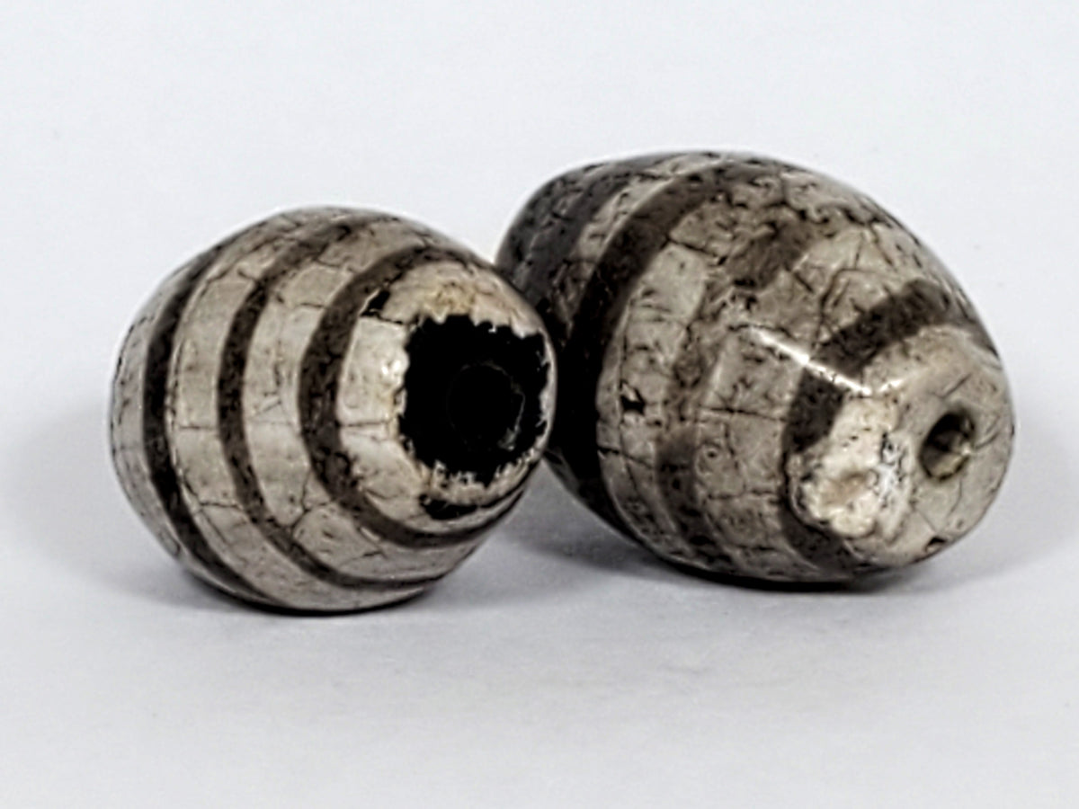 Ac-062626-9SChung2 pair ancient Chung dzi, drill end view, chip disclosed Bead A, dark end cap colouration, unretouched