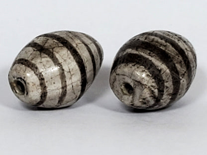 Ac-062626-9SChung2 pair ancient Chung dzi, drill end view, stripe softening age detail visible, unretouched
