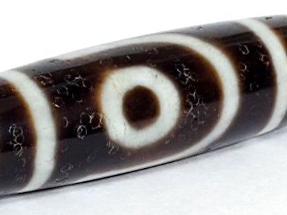 V-070226-2E dzi bead, macro view of eye motif showing natural surface pitting, unretouched.
