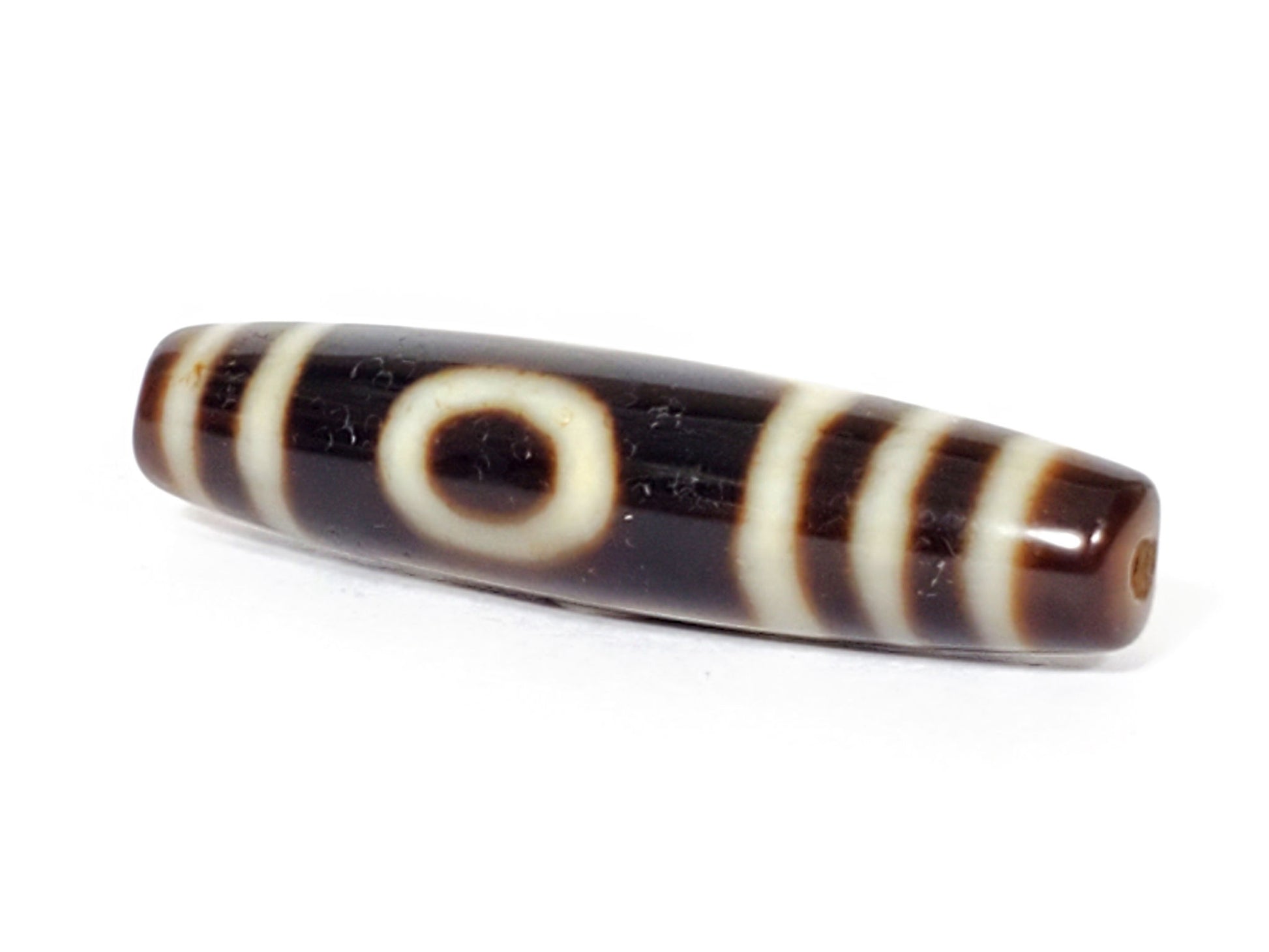 V-070226-OEM dzi bead, close view of central eye motif, dark brown agate, unretouched photo.