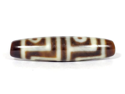 V-070226-4E dzi bead, straight-on view, dark brown stepped motif on cream ground, unretouched photo.