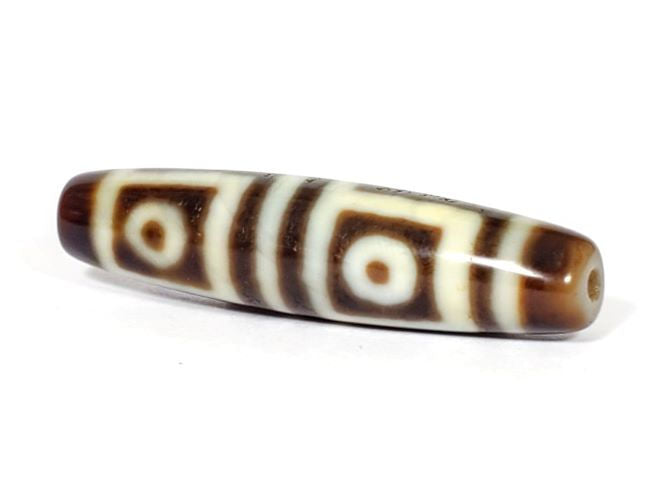 V-070226-4E dzi bead, diagonal view showing drill hole, dark brown motif, unretouched photo.