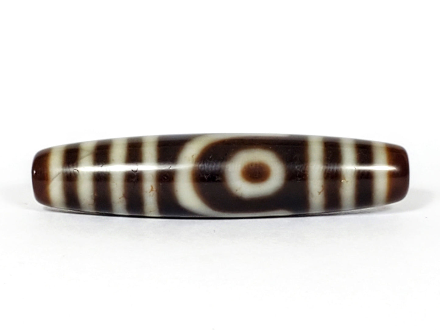 V-031122-2E vintage two eye dzi bead, front view, brown ground, triple-bar ends, 50.0×11.4mm, unretouched.