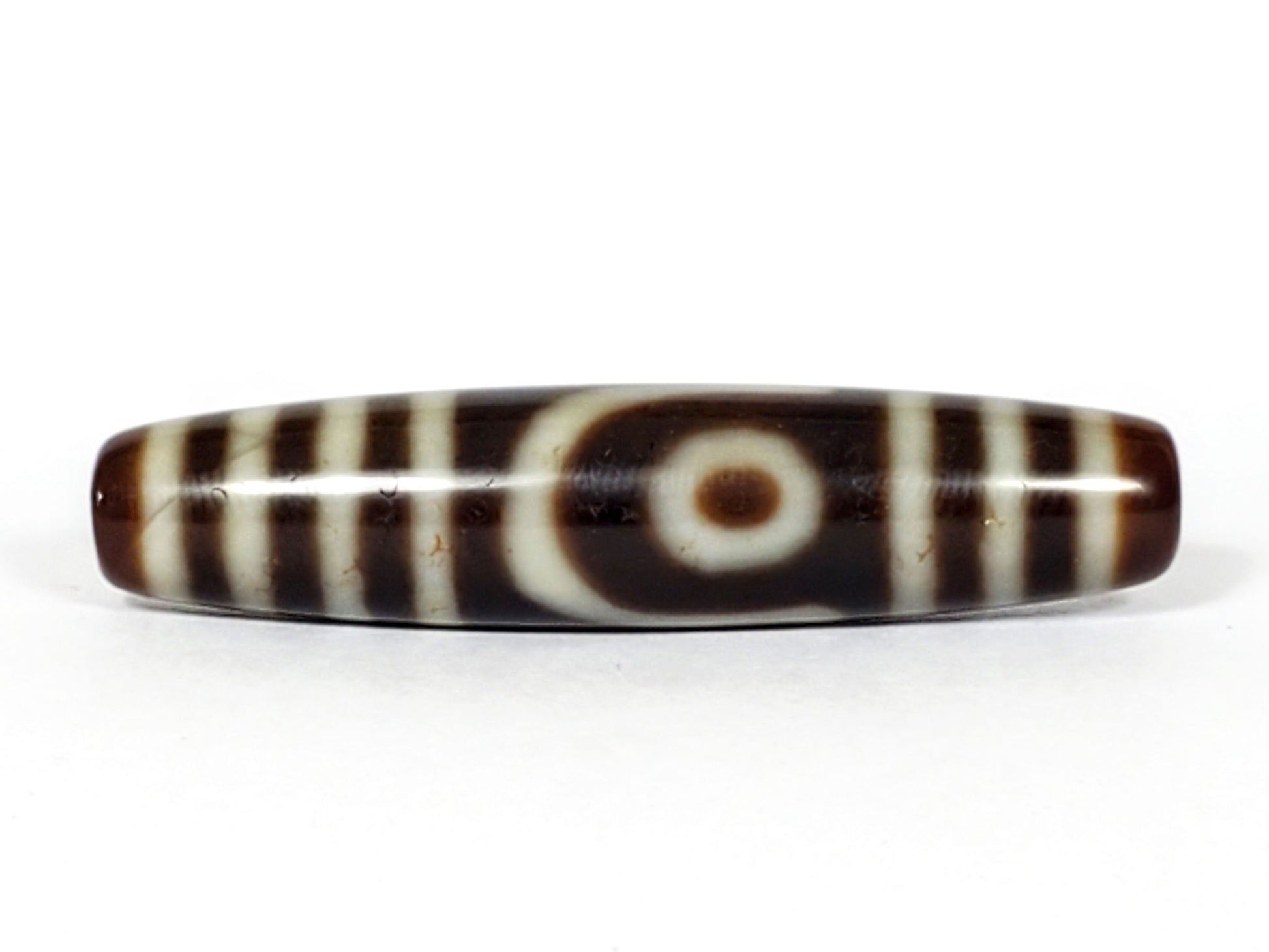 V-031122-2E vintage two eye dzi bead, front view, brown ground, triple-bar ends, 50.0×11.4mm, unretouched.