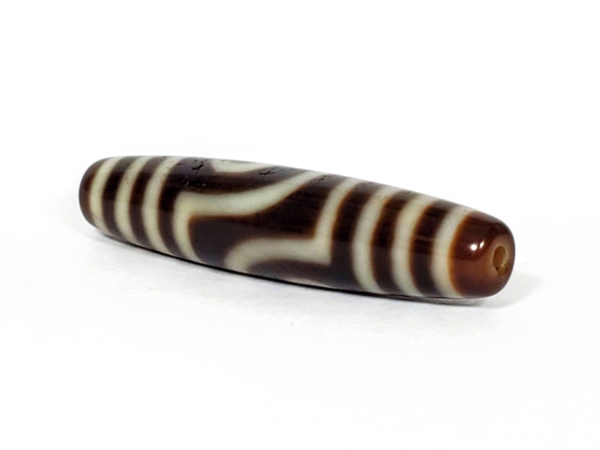 V-031122-2E dzi bead, angled view showing stepped-line face, dark brown, unretouched.