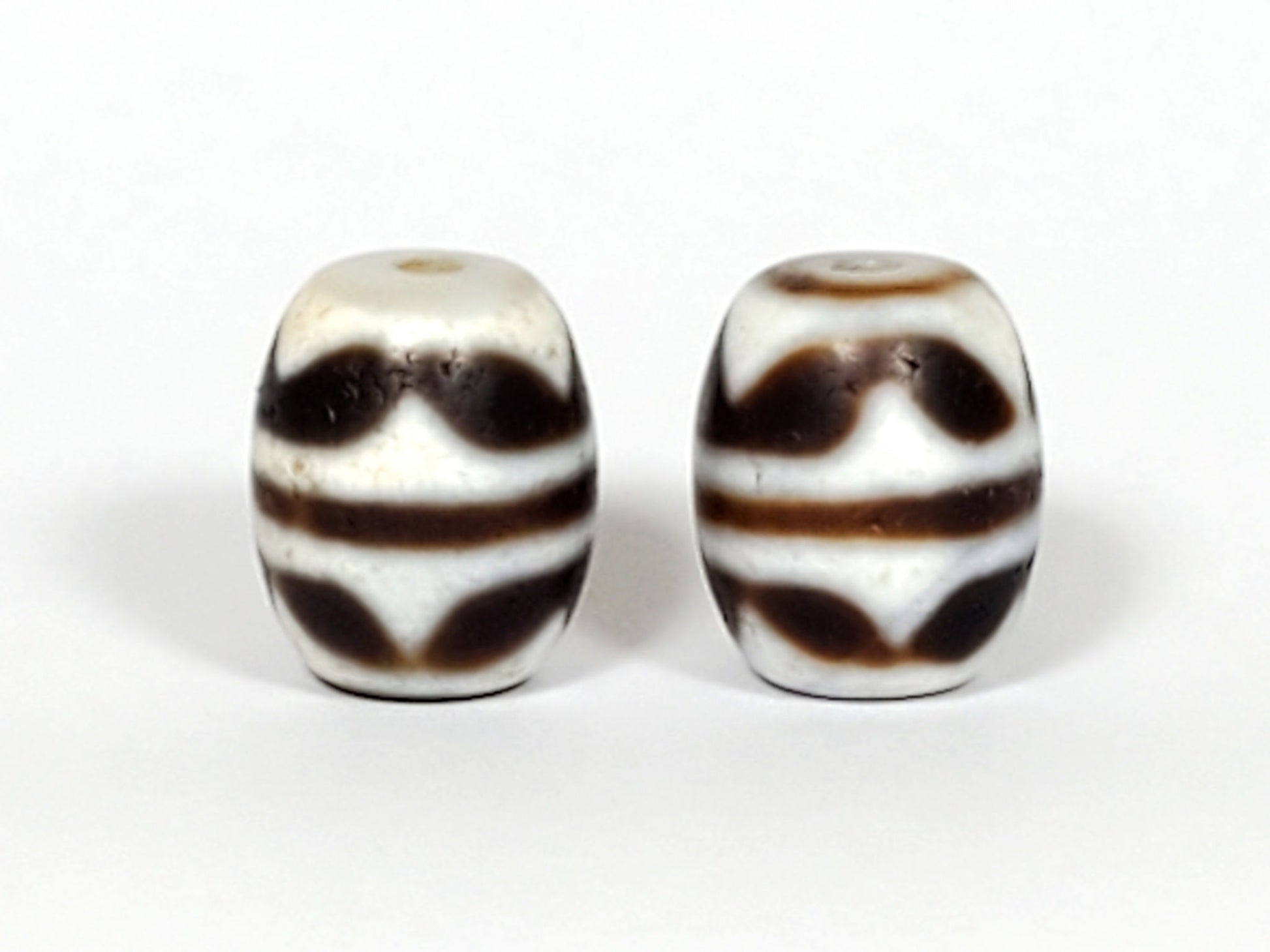 V-041122-DTT pair vintage double tiger tooth dzi, front face, cream-white ground, 14.8×12.2mm, unretouched