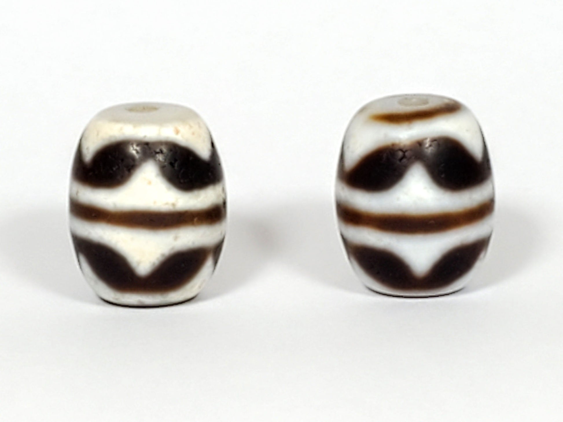 V-041122-DTT pair vintage double tiger tooth dzi, third face, lower tooth visible, cream field dominant, unretouched 