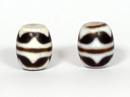 V-041122-DTT pair vintage double tiger tooth dzi, third face, lower tooth visible, cream field dominant, unretouched 