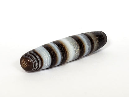 N-N-062126-CS1 natural agate dzi, three-quarter angle showing opposite drill hole, full band sequence, unretouched