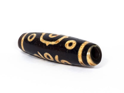 V-FA-062126-14E-LK dzi bead, angled view showing large keyhole drill hole, unretouched
