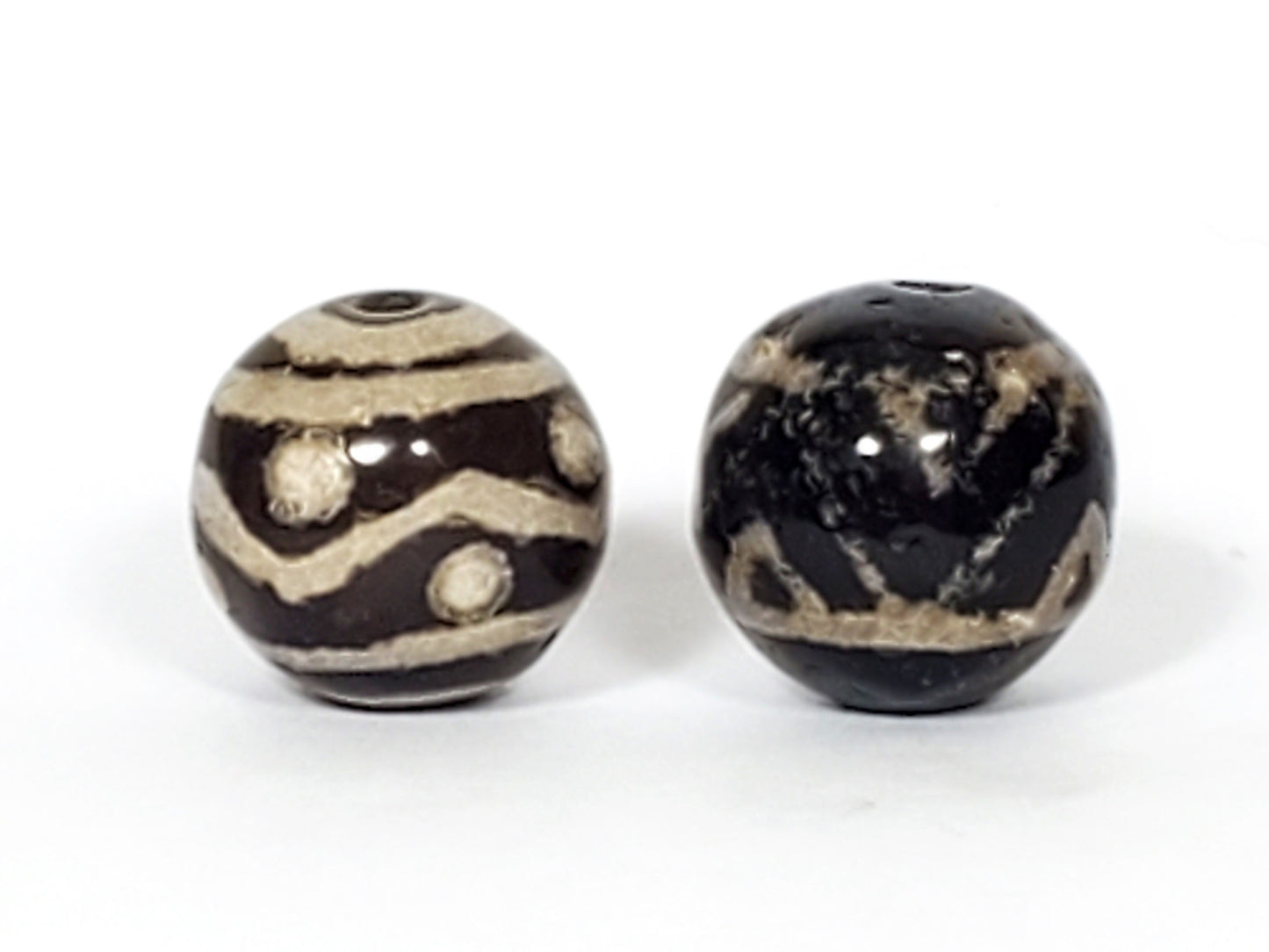 V-FA-062526-TSWS-TT pair round agate dzi, front view, black ground, sandy-cream motifs, 13.8×13.7 & 13.6×13.2mm, unretouched
