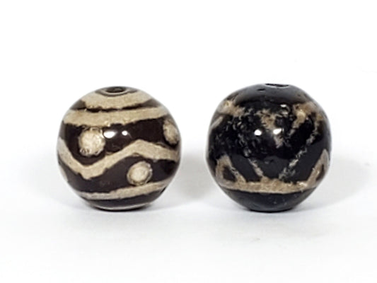 V-FA-062526-TSWS-TT pair round agate dzi, front view, black ground, sandy-cream motifs, 13.8×13.7 & 13.6×13.2mm, unretouched