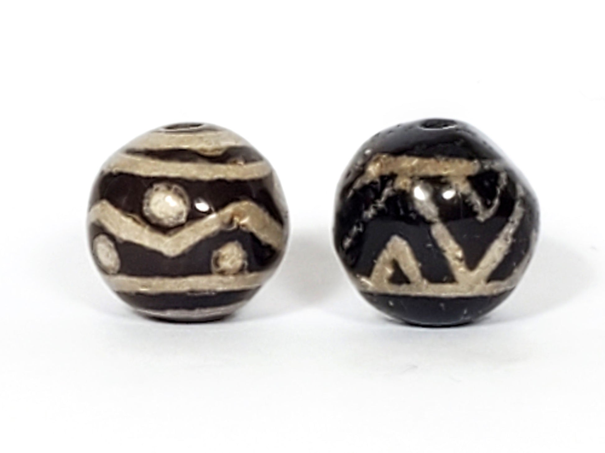 V-FA-062526-TSWS-TT Bead A tiger stripe wave star, Bead B tiger tooth wave, side view, black ground, sandy-cream, unretouched