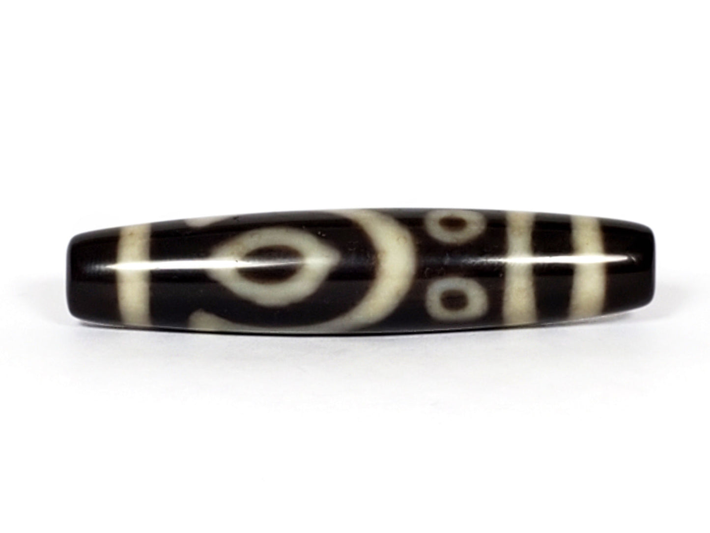 V-070226-4E2 vintage four eye dzi bead, front view, black ground with cream eye motif, 53.9×11.6mm, unretouched.