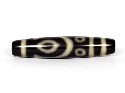 V-070226-4E2 vintage four eye dzi bead, front view, black ground with cream eye motif, 53.9×11.6mm, unretouched.