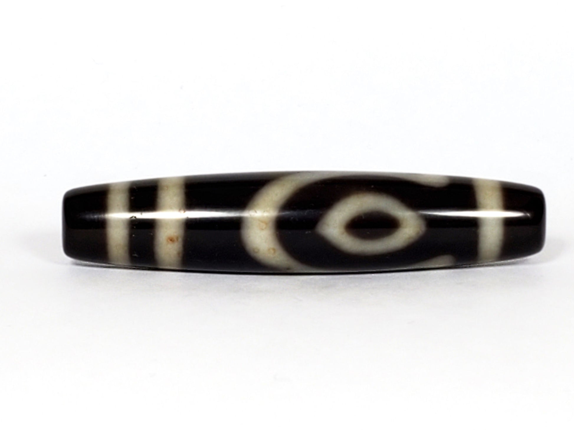 V-070226-4E2 dzi bead, eye motif face, black agate with cream rings, unretouched photo.