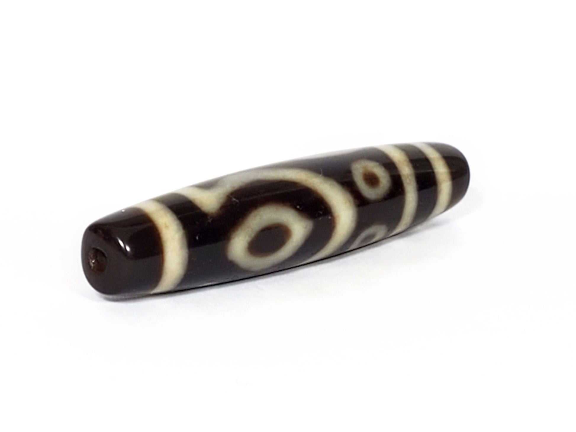 V-070226-4E2 dzi bead, full diagonal view, cream eye and stripe motif on black, unretouched.