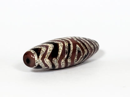 At-071322-3ETT antique carnelian dzi, angled left end view, drill hole, etched stripe texture close-up, unretouched