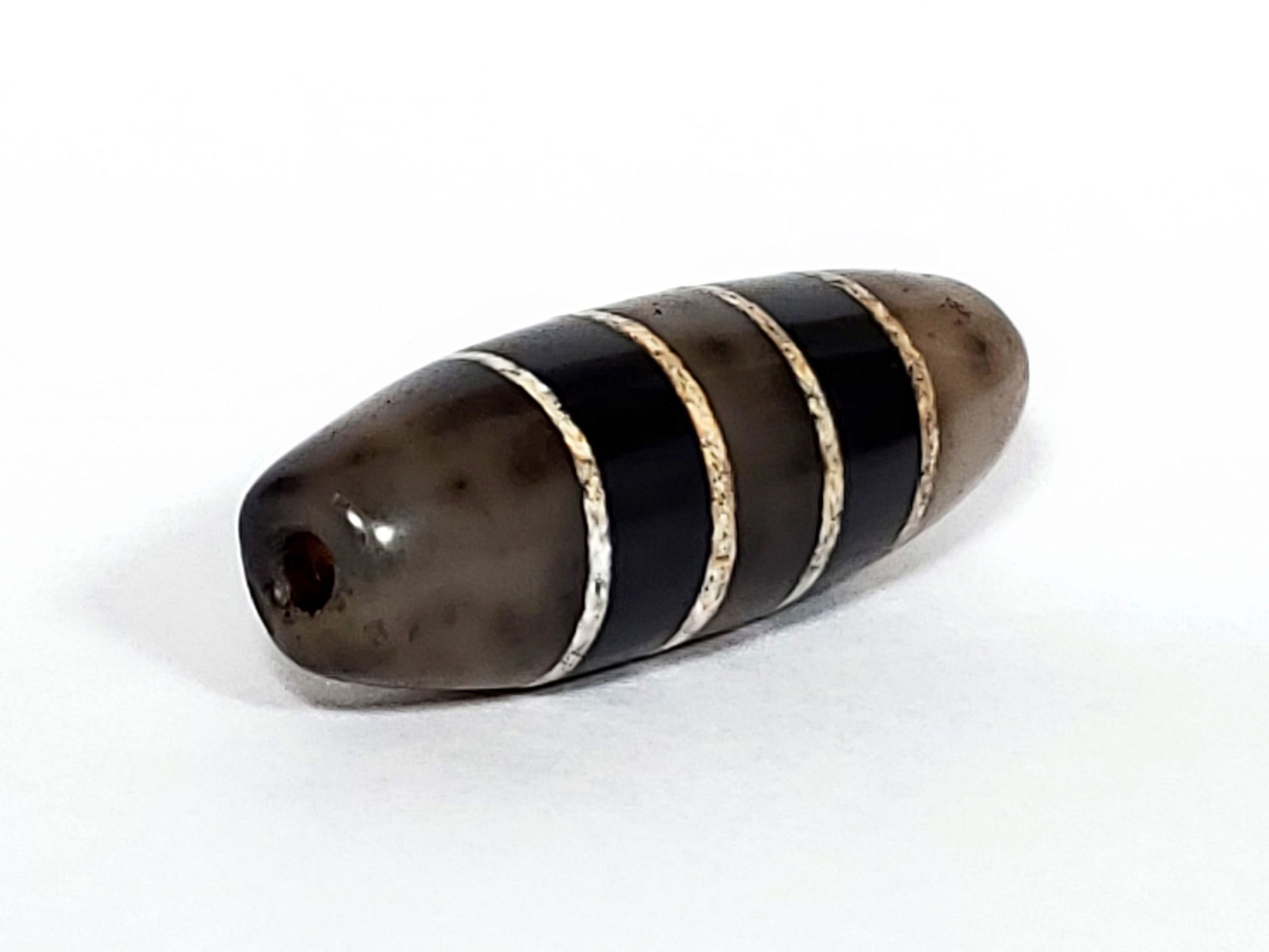 Ac-101922-7SChung, left tip, drill hole, translucent cool grey end cap, compact short-wide form visible, unretouched
