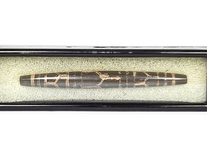 Ac-062926-3LG in display case, 75.3×8.2mm ancient triple longevity dzi, pitch-black agate warm-tan motif lines, unretouched