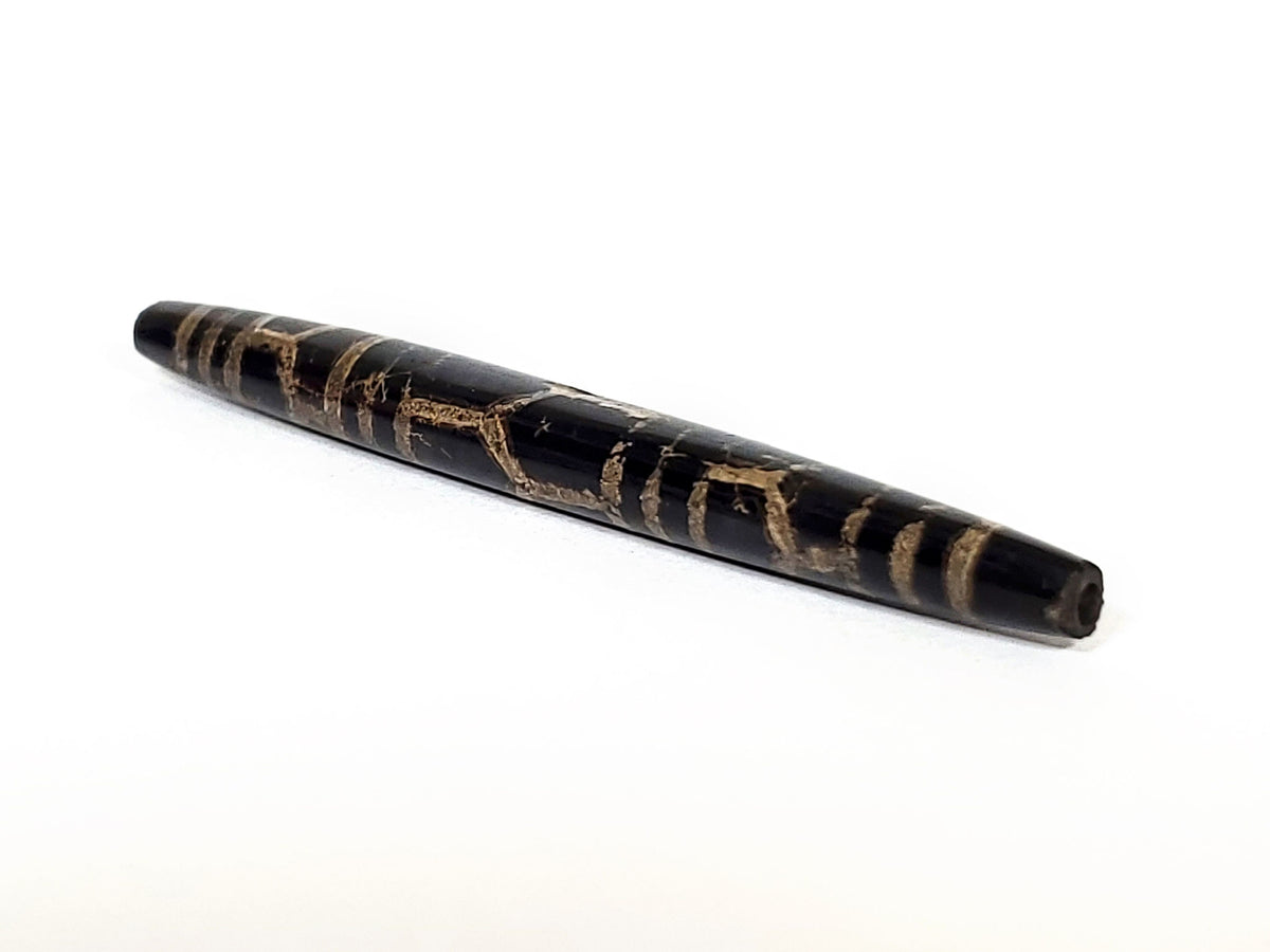 Ac-062926-3LG angled drill-end, pitch-black tapered barrel, aged tan motif lines, ancient longevity dzi, unretouched