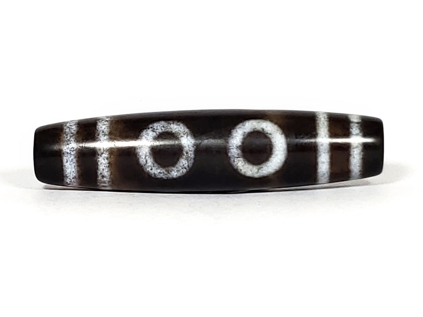 N-062226-6E, face B, three closed concentric ring eyes, H-bar dividers, very deep dark brown ground, unretouched
