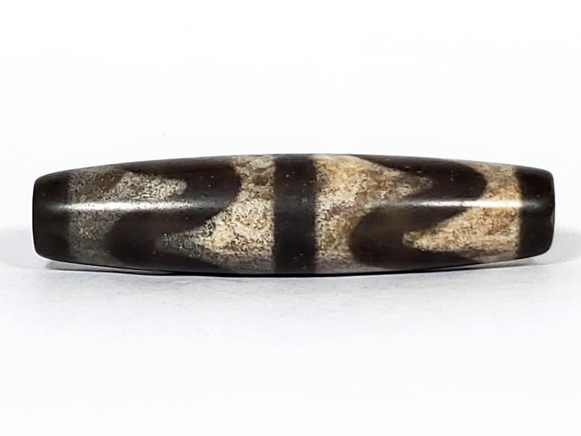 N-062226-DW2, face B, double wave motif, warm sandy-beige granular field, very dark brown agate ground, unretouched