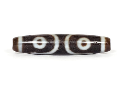 V-070226-ThE-001 dzi bead, reverse face showing two eyes with looping lines, unretouched photo.