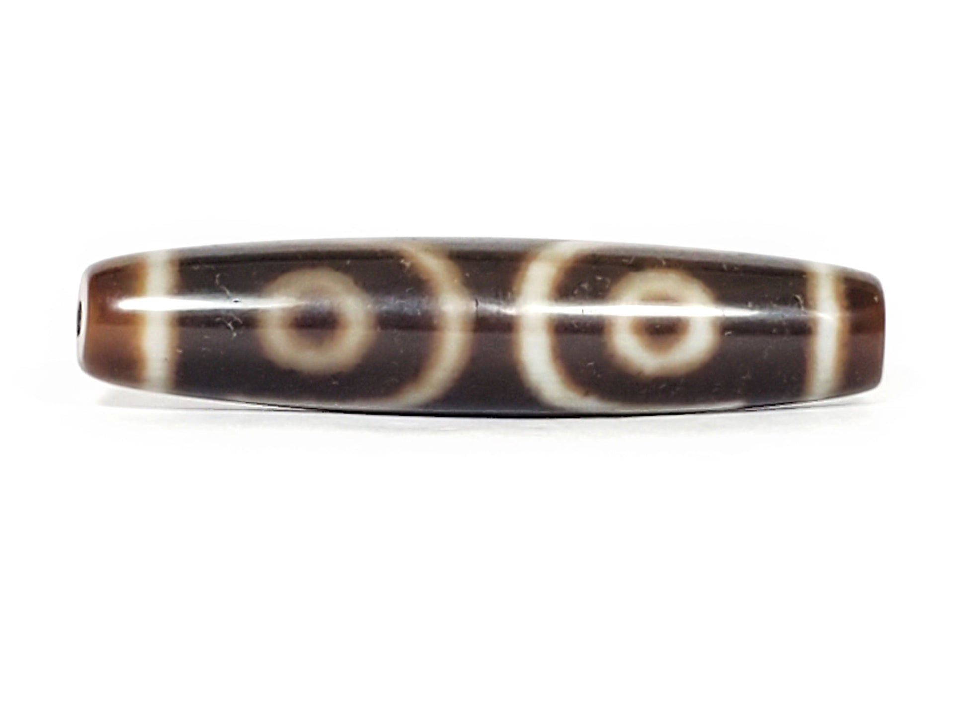 V-070226-ThE-003 dzi bead, reverse face showing two eyes with curved arcs, dark brown, unretouched.