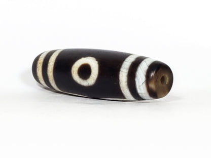 N-070226-3E dzi bead, diagonal view showing drill hole and single eye face, black agate, unretouched.