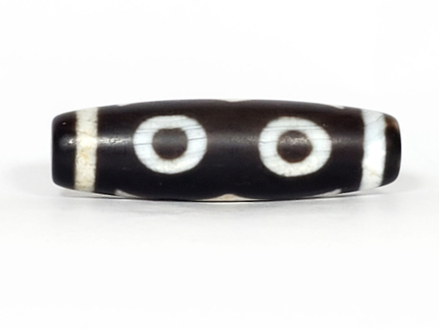 N-070226-3E dzi bead, reverse face, two eyes joined by wave motif on black ground, unretouched.