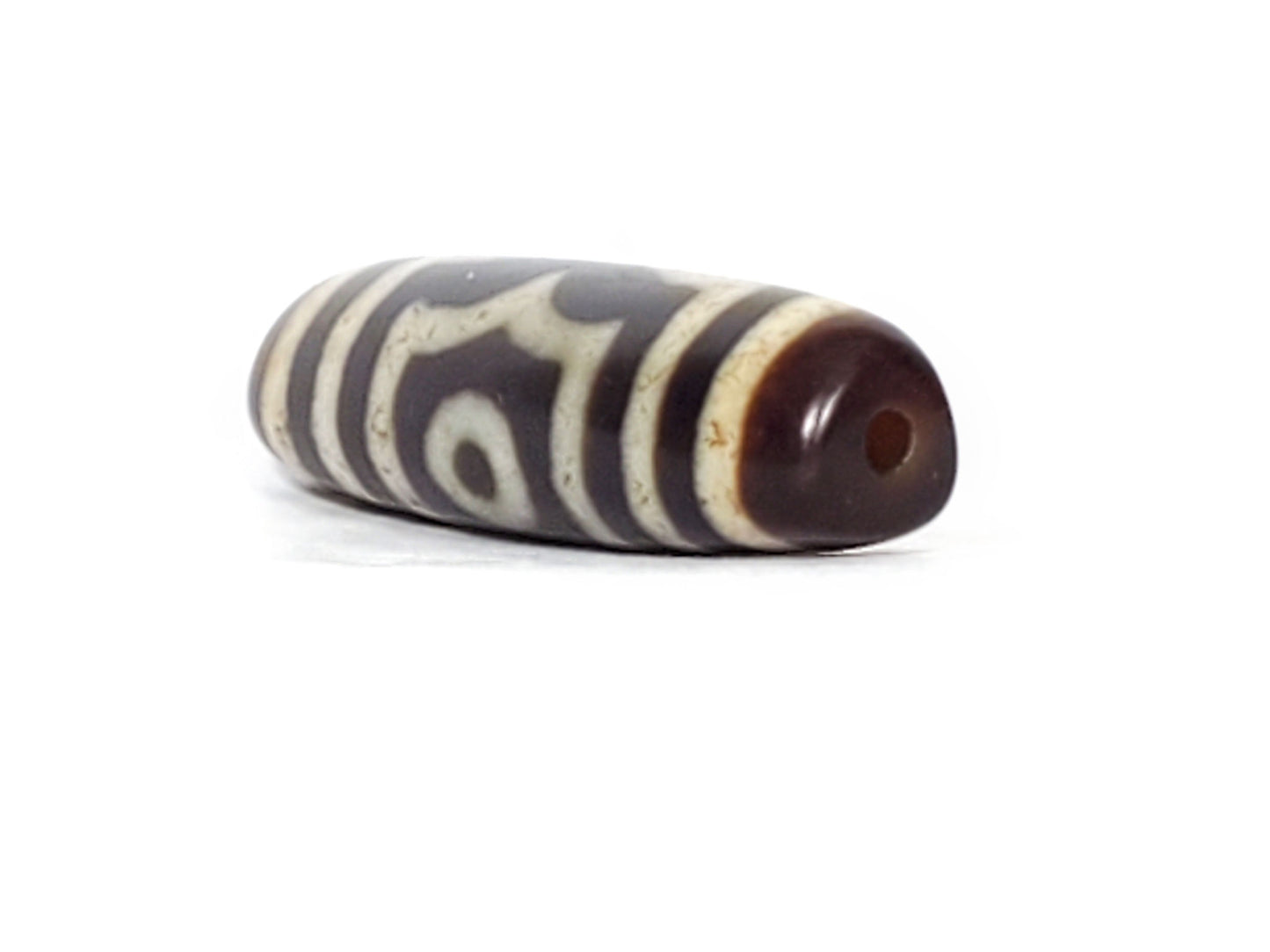 V-070226-3E dzi bead, diagonal view showing drill hole and single eye face, dark brown end, unretouched.