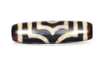 V-070226-3E dzi bead, wave-pattern face, black ground with cream chevron lines, unretouched.