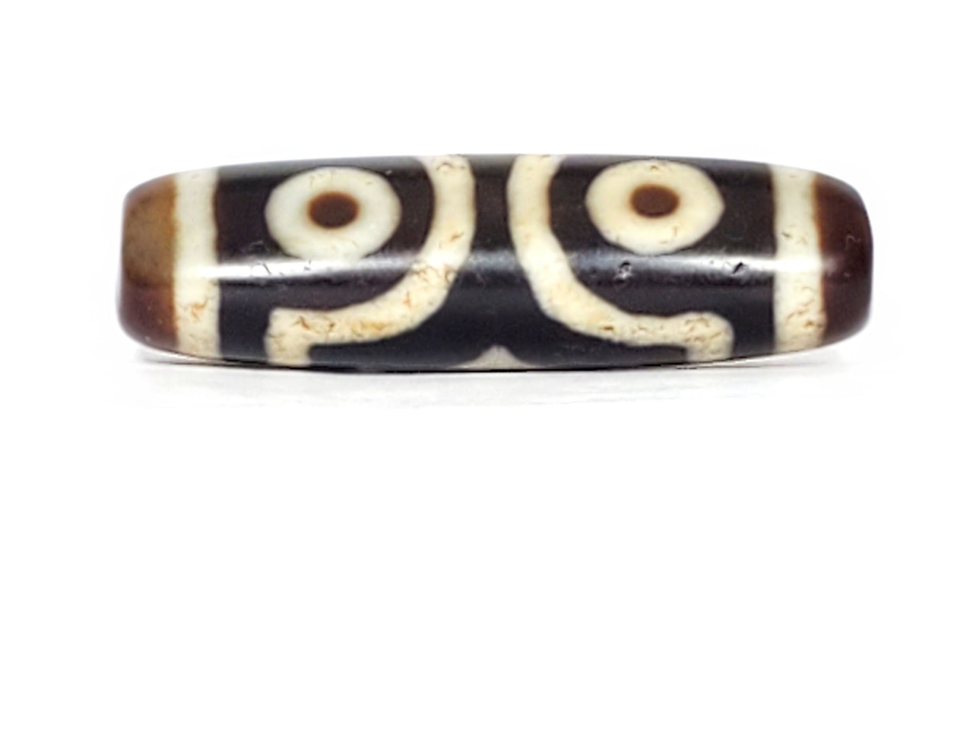 V-070226-3E dzi bead, two-eye spiral face, black ground with cream motif, unretouched photo.