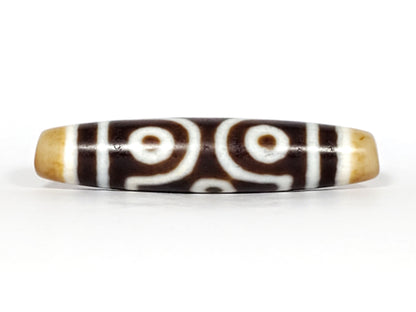 Face A, two open C-ring eyes + scroll):
Antique six eye dzi At-053026-6E, Face A, two open C-ring eyes with scroll connector on deep brown agate, honey-gold end caps, 54.9mm × 12.3mm, unretouched