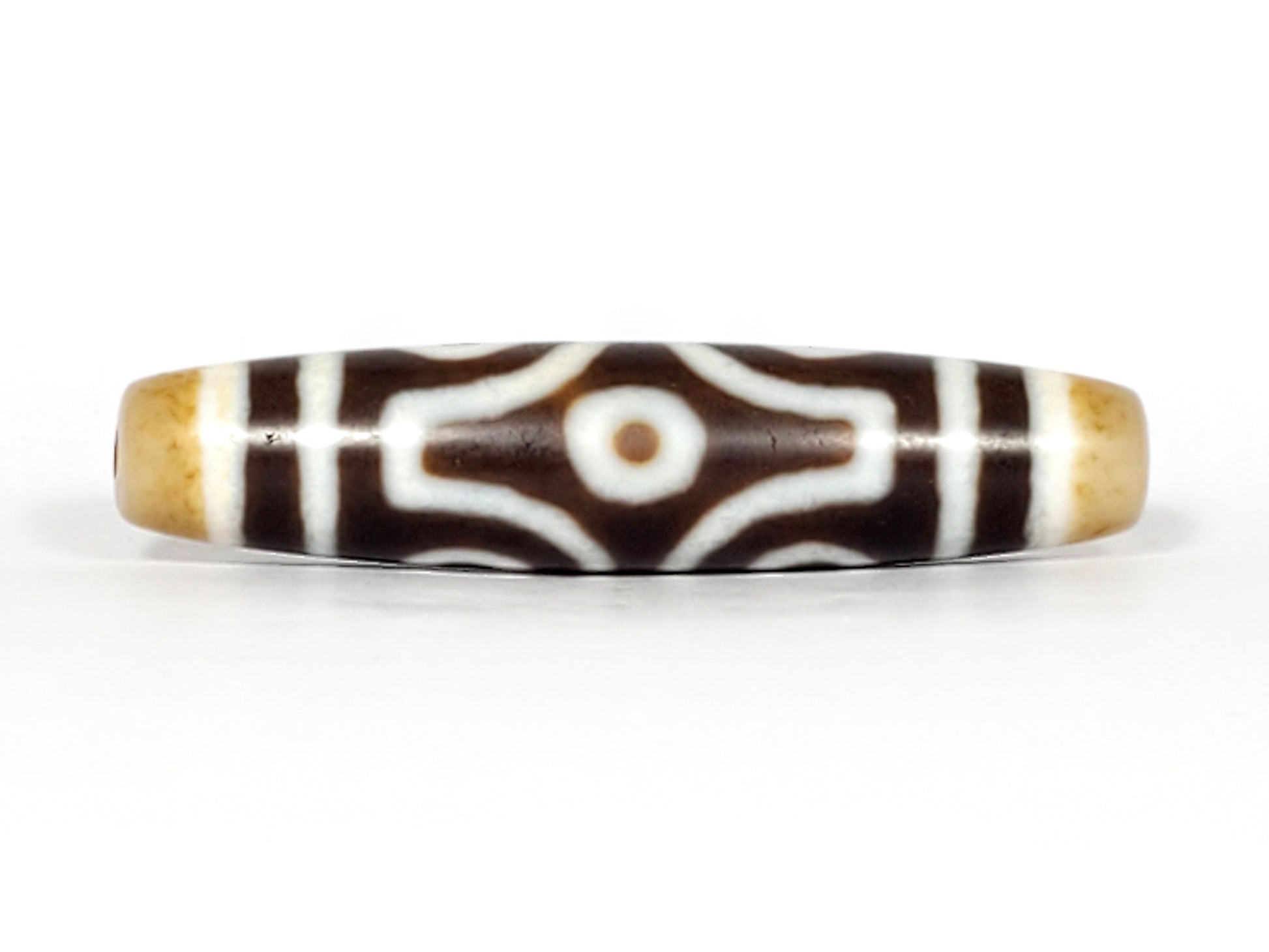 Face D, diamond frame single eye): Face D of antique six eye dzi At-053026-6E, single eye within diamond compass-rose frame on deep brown agate, honey-gold end caps, 54.9mm × 12.3mm, unretouched