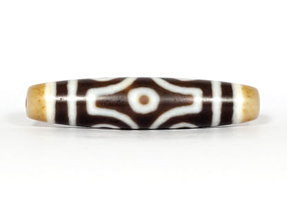 Face D, diamond frame single eye): Face D of antique six eye dzi At-053026-6E, single eye within diamond compass-rose frame on deep brown agate, honey-gold end caps, 54.9mm × 12.3mm, unretouched