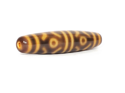 At-053126-6ETT, opposite end-cap angled view, honey-gold cap with hole, chocolate-brown body, six eye motif, unretouched
