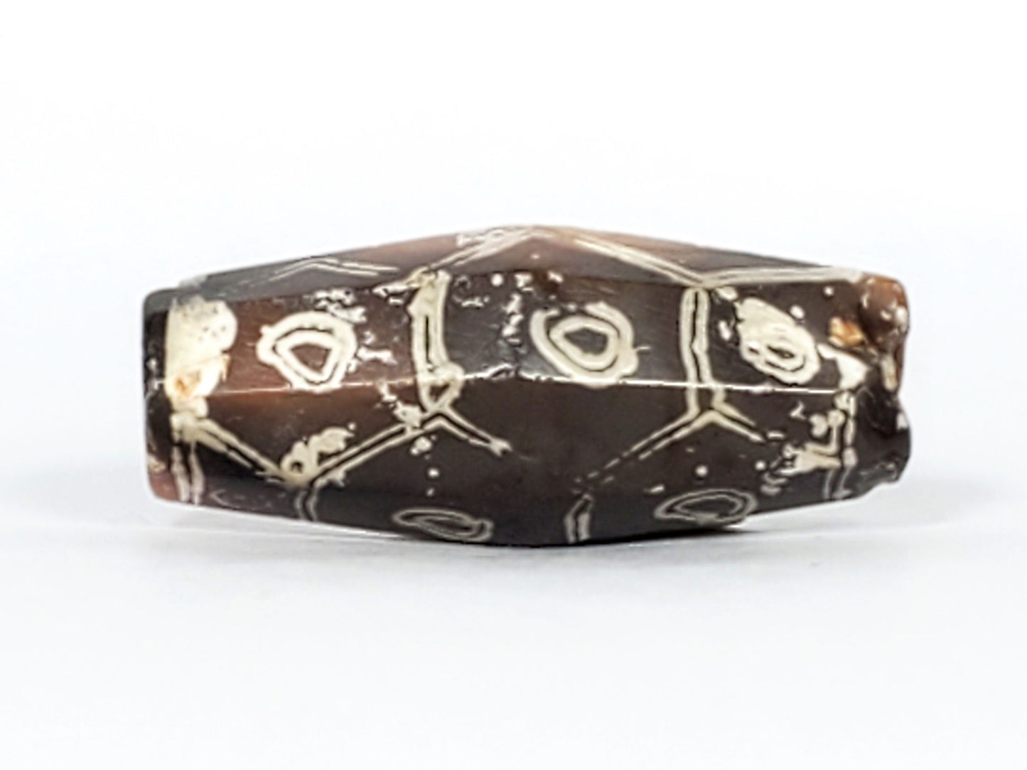 Ac-030223-12E top face, 3 eyes on deep grey-brown ground, cream-white hexagonal cell framing, unretouched