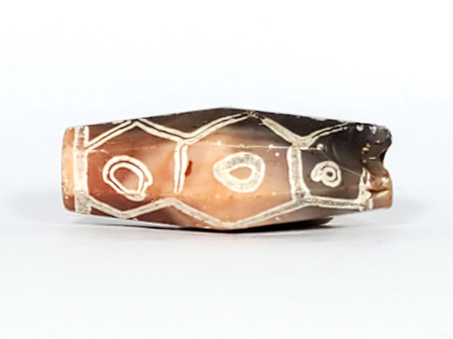Ac-030223-12E warm terracotta-orange face, 3 eyes cream-white etching, hexagonal cell frames, unretouched