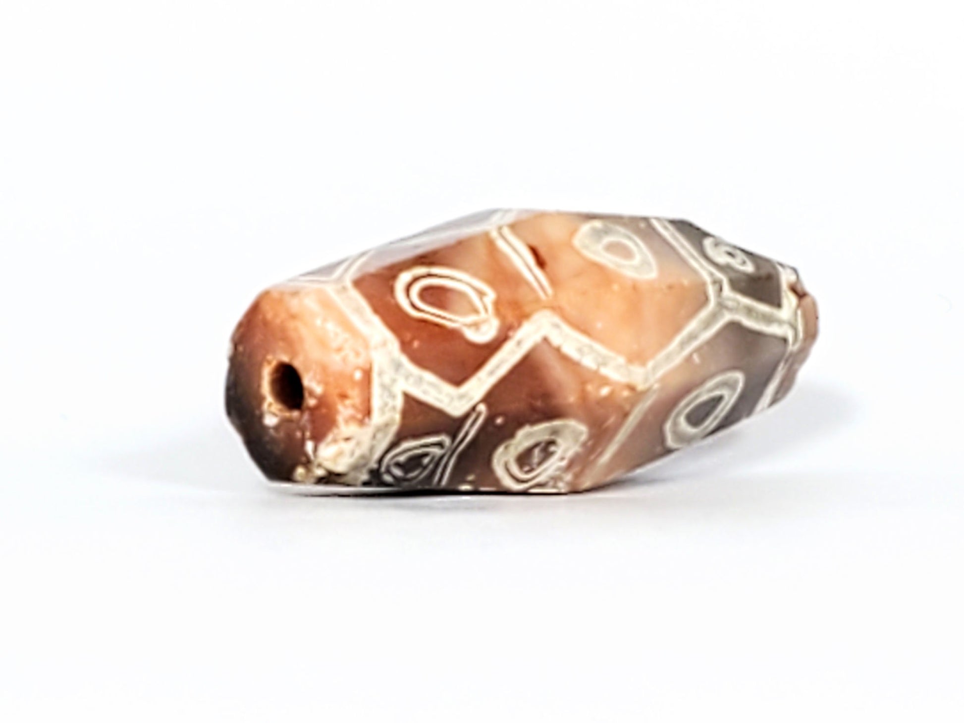 Ac-030223-12E drill hole end cap, warm terracotta-orange, ancient drill hole, eyes wrapping body, unretouched