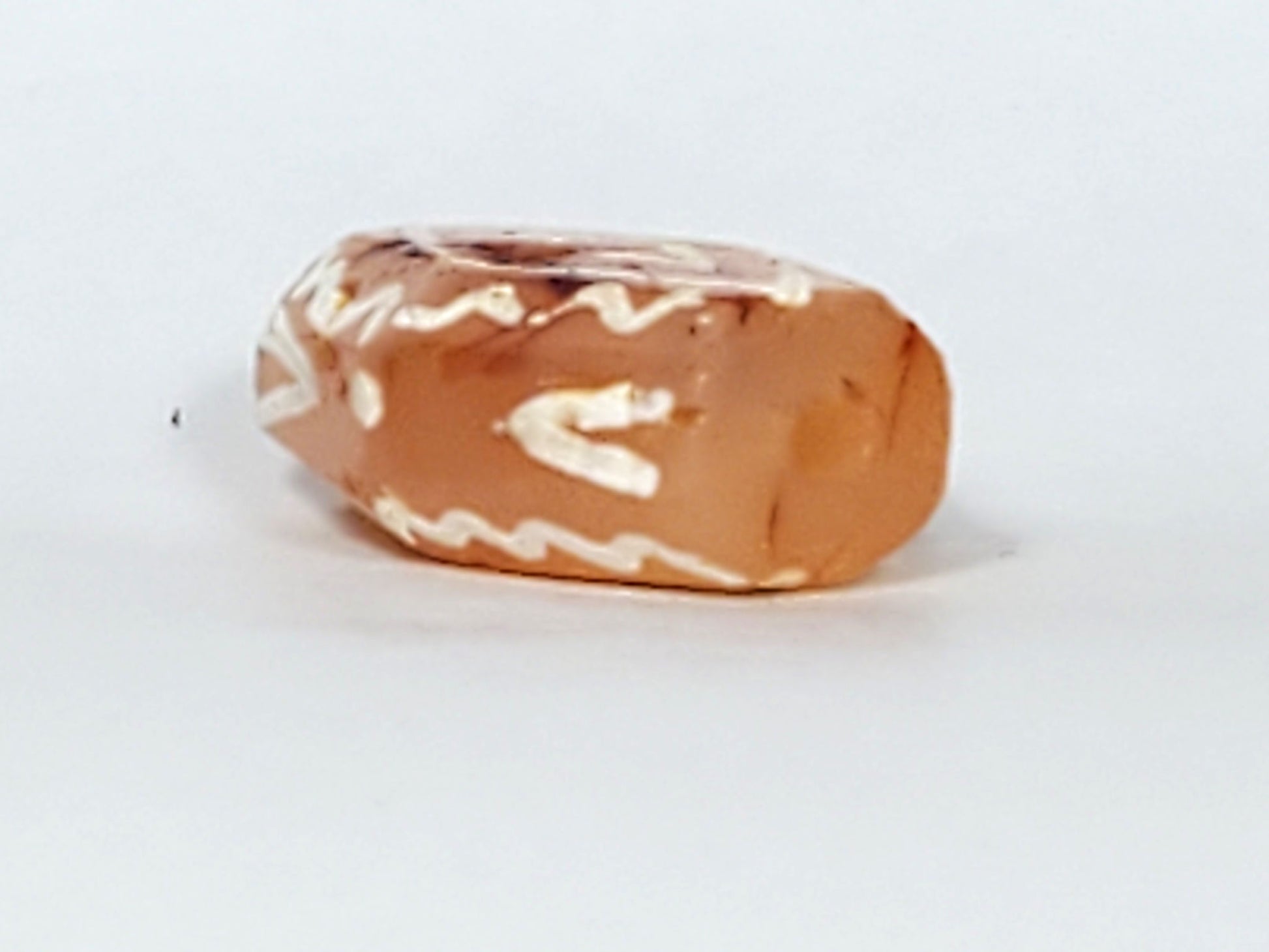 Ac-030623-DDIE carnelian dzi end view, raw terracotta-orange carnelian form, drill hole visible, unretouched