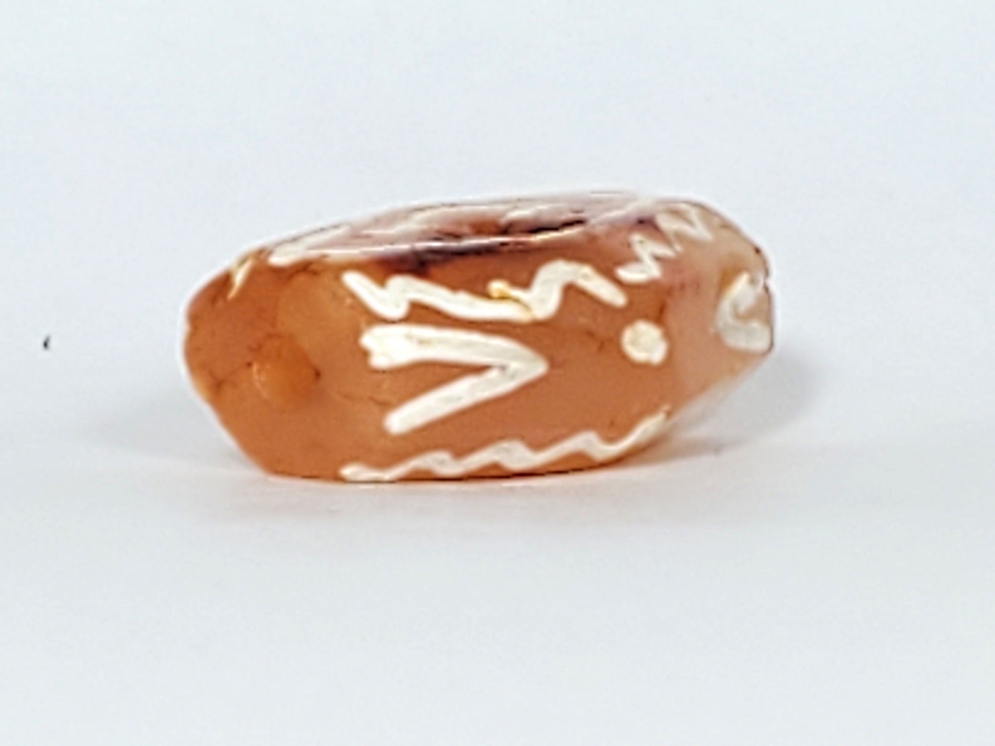 Ac-030623-DDIE carnelian dzi end, brown-red cinnabar bloodspot inclusions on terracotta-orange surface, unretouched