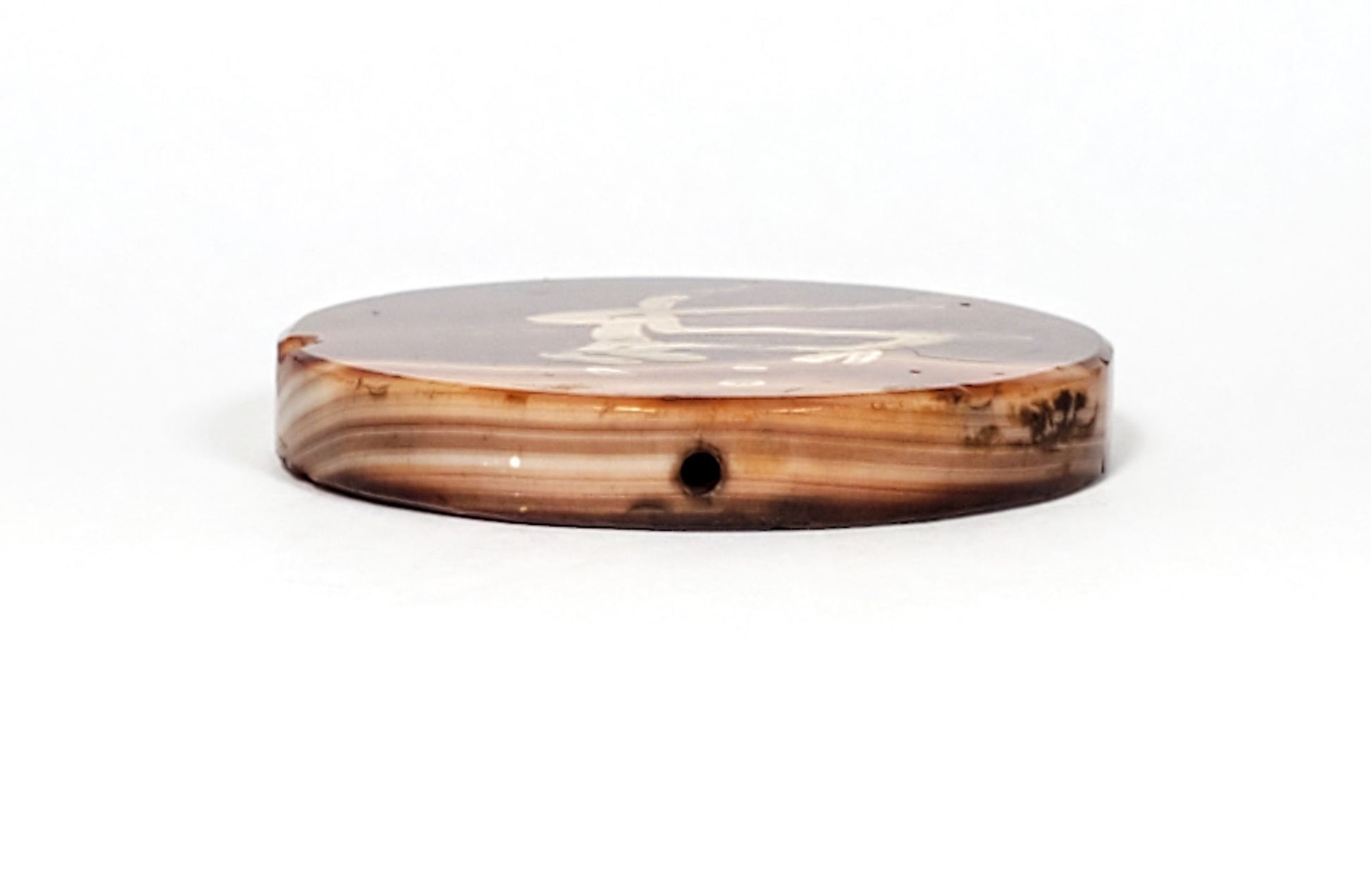 At-062926-DD edge profile, drill hole visible, warm orange-red honey cream banded carnelian layers, unretouched