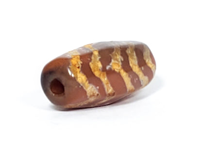 At-030823-5TSR angled end view, small centred drill hole, warm reddish-brown end cap, chevrons visible, unretouched