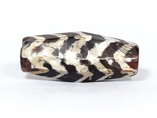Ac-030823-5TS2 hero, three-quarter view, 28.6×12.9mm carnelian dzi, 5 chevron tiger stripes, heavy calcification, unretouched