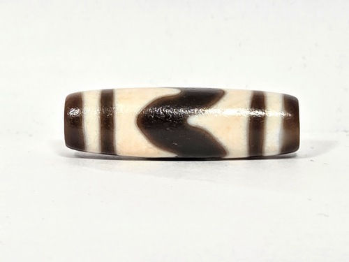 Vintage tiger tooth dzi bead V-030326-TTBS, 35.6×11.1mm, front face, cream ground, dark dark brown teeth motif, unretouched.