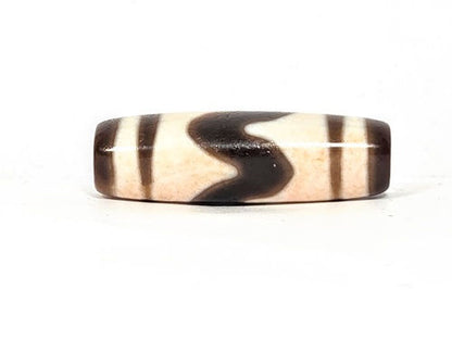 V-030326-TTBS vintage tiger tooth dzi, rotated 180°, cream-dominant face, dark dark brown motif at upper edge, unretouched