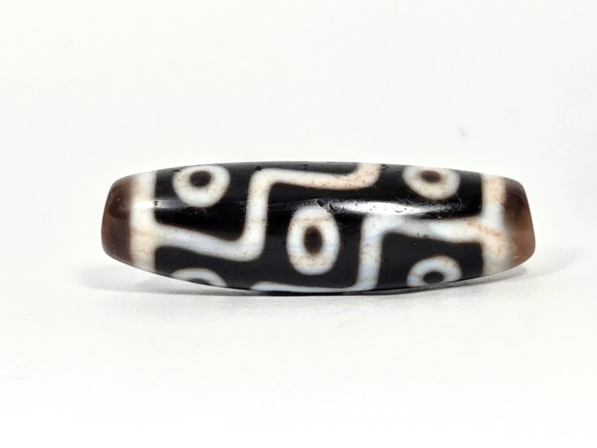 At-070626-9EBS antique nine eye dzi face B, black ground, warm brown end caps, bold cream stepped eye motif rotated, unretouched